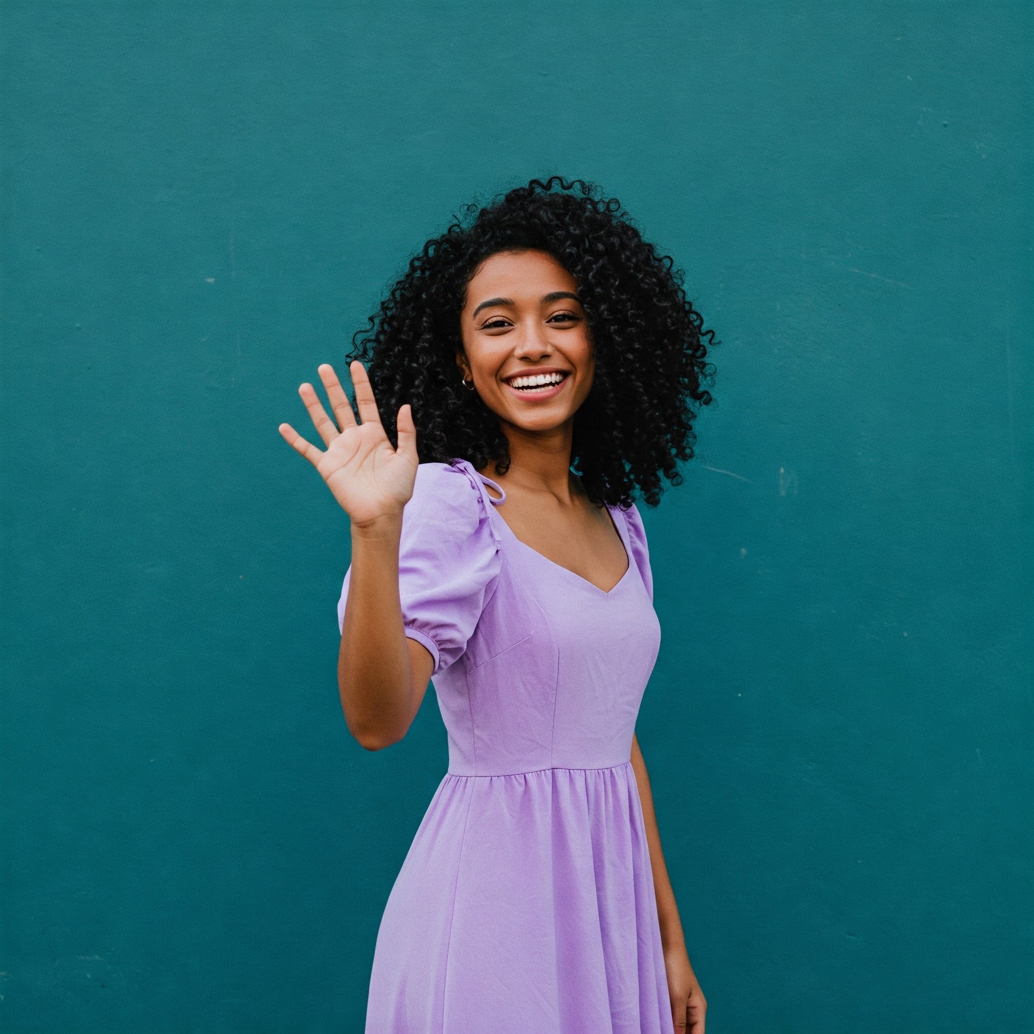 photo of Cheerful Woman Waving Hello to viewers